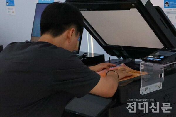 우리 대학 근처 인쇄소에서 기자가 교재를 스캔하는 척 하고 있다.