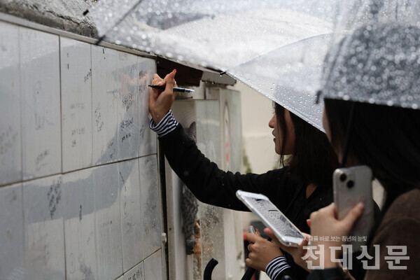 안정현씨가 펭귄마을 벽면에 글귀를 남기고 있다.